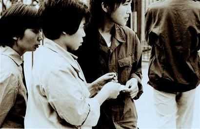 图为1988年，武汉一位女同胞经过一场“奋战”，终于买到一枚24K金的黄金戒指，此刻，她似乎仍在回味着抢购的情景。