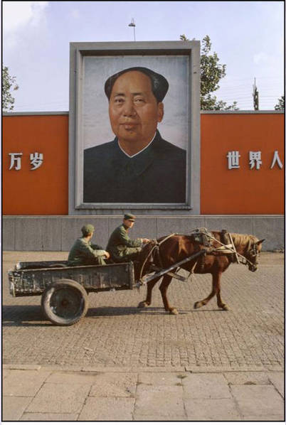 这是一组法国摄影师Bruno Barbey于1973年在中国拍摄的照片，反应了1970年代初期中国社会的风貌。Bruno Barbey是一个法国人，出生在非洲的摩洛哥。他在瑞士韦威的cole des Arts et Métiers学习了摄影和绘画艺术。图为两名军人打扮的人驾着马车经过毛泽东画像前。