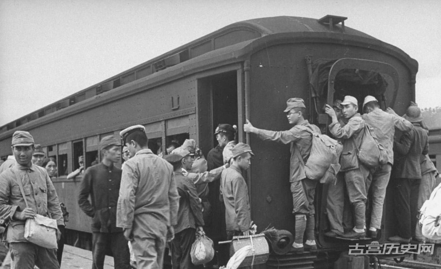 在平台的复原士兵带着他们的装备登上拥挤的火车，有人已经在演绎日本版的“火车挂票”回家的路虽然艰辛，但对战后余生的士兵来说却是最好的勋章和褒奖。地点：日本广岛。
