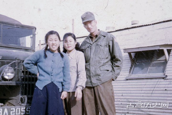 美国记者和韩国民众合影，受战争影响，记者也穿起来混搭风格的军服。