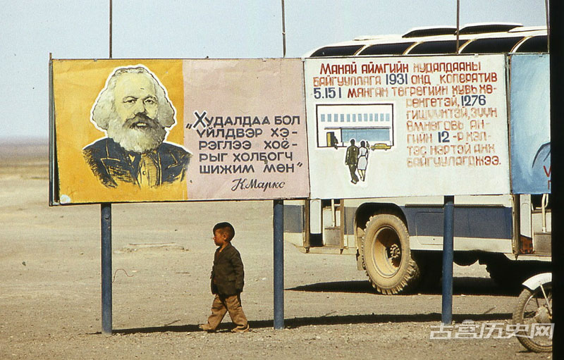 蒙古人民共和国是蒙古国的前身，是东亚第一个社会主义国家（也是世界上第二个社会主义国家），首都乌兰巴托，1945年脱离中国，联合国承认其合法地位。图为在沙漠里卡尔·马克思海报下的男孩。