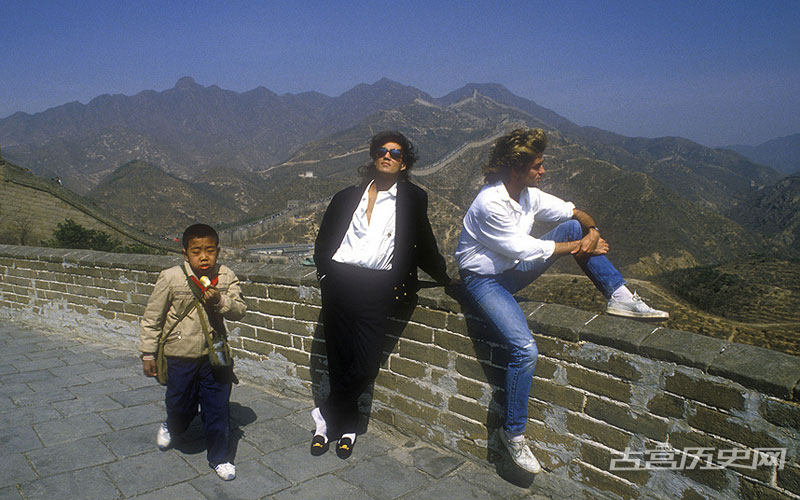 1985年4月，乔治·迈克尔和安德鲁·维治利游览长城，一位春游的小学生从他们身边走过。