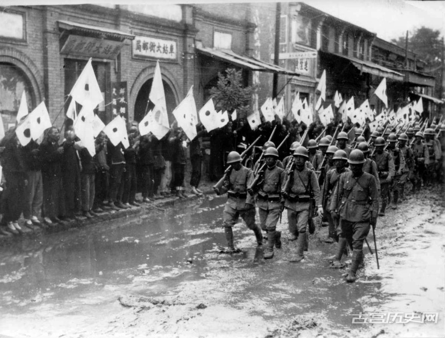 1937年，日本士兵在占领中国河南省的城市大街上游行。