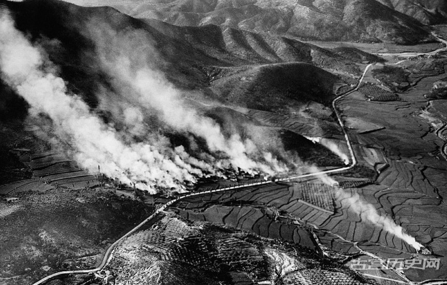 1950年，从南韩北部Agok村庄的废墟上，浓烟升起。