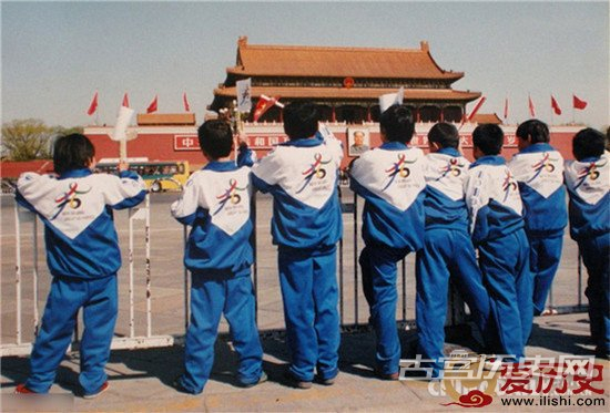 　2001年春，北京天安门广场，几位身穿印有奥运五环图案校服的小学生举目远望，期盼北京奥运早日申办成功。